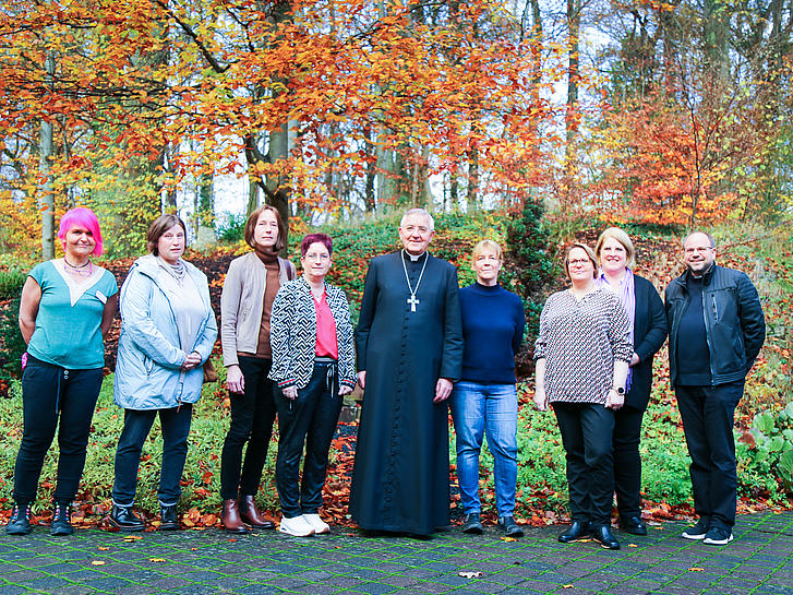 Ein Gruppenbild zeigt Weihbischof Franz Josef Gebert gemeinsam mit dem Team des Alten-und Pfelgeheims St. Sebastian Nunkirchen unter einem herbstlich gefärbten Baum