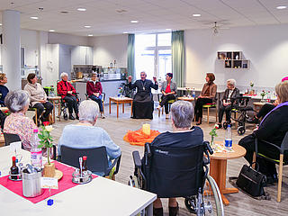 Weihbischof Franz Josef Gebert sitzt gemeinsam mit den Teilnehmer*innen in einem Sitzkreis und diskutiert